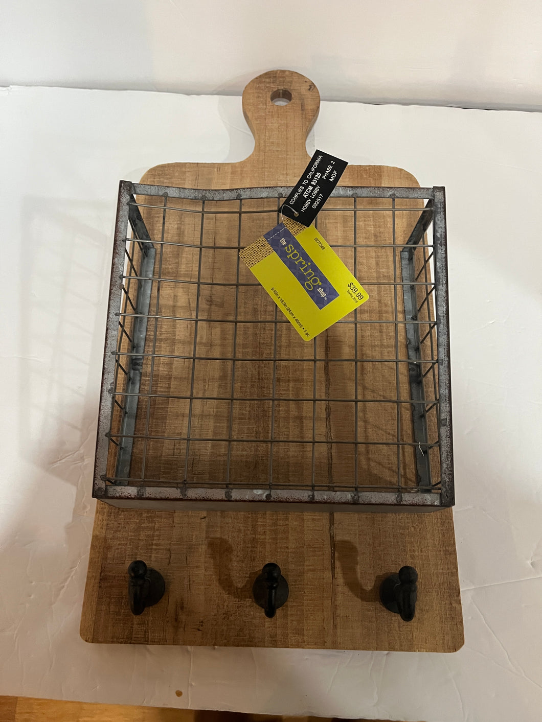 Wall hanging cutting board with hooks and basket.